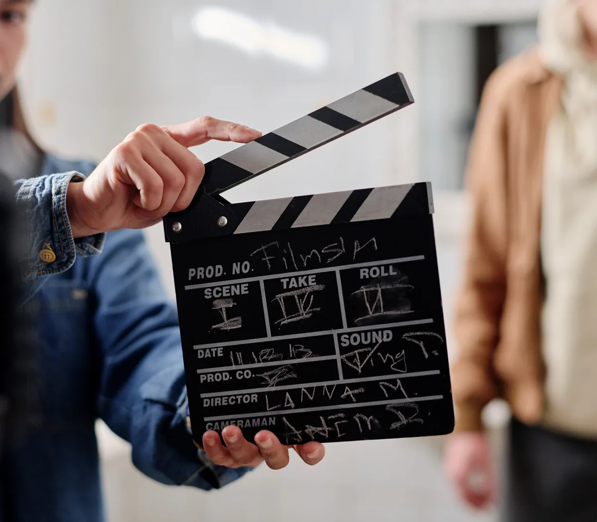 A clapperboard held up on a film set, marked up for the next take