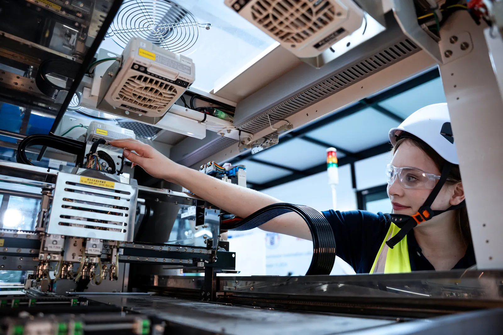 An engineer working on complex machinery on a factory floor