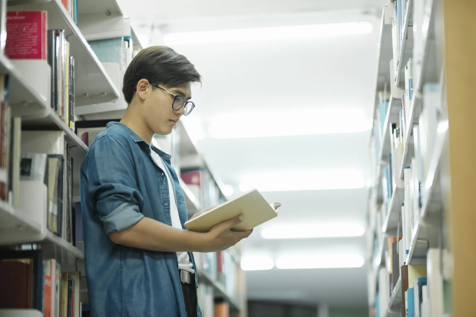 A student pulling a book in a university library